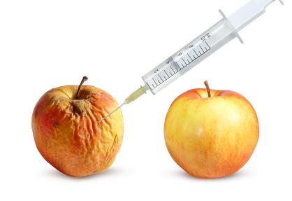 Wrinkled apple and a nice apple and syringe on a white background