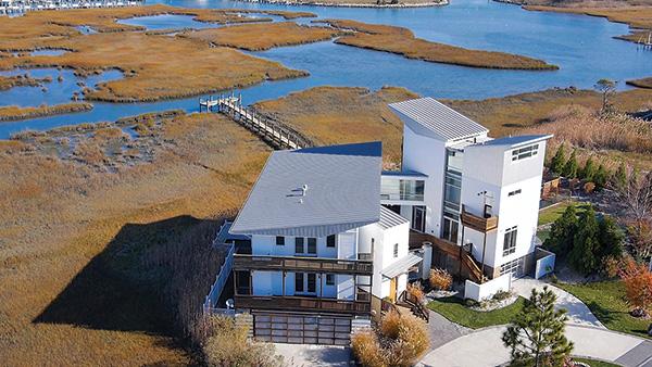 The 6,050-square-foot beach house beside Isle of Wight Bay in Ocean City, Md., includes a main house and guest wing spanned by a glass bridge.