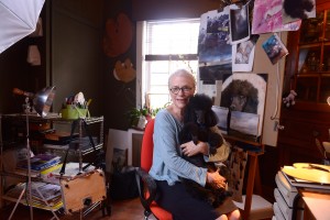 Harriet Cole holding poodle Arthur in her studio.
