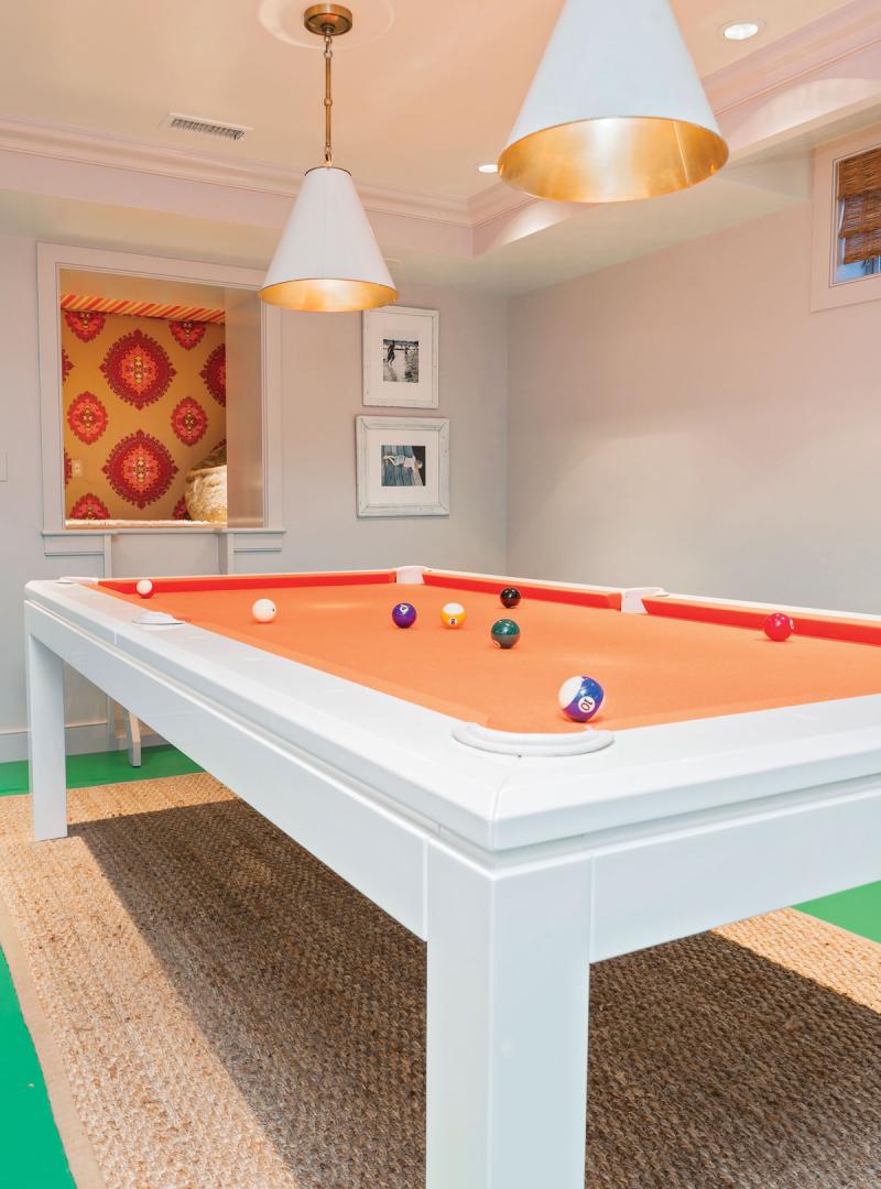 An orange lacquered pool table lives on the green epoxy floor, and a cute custom-created nook overlooks all.