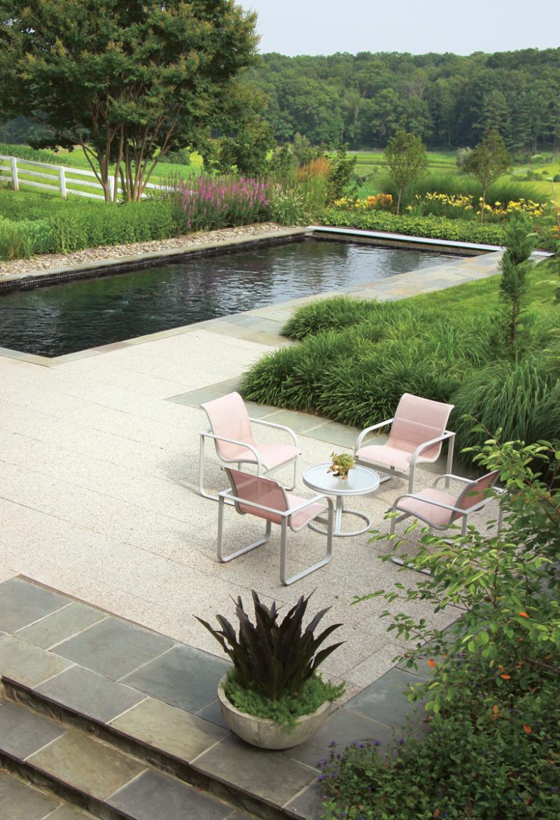 Deep perennial borders surround a black-lined pool.