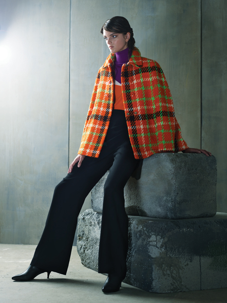 Mad for Plaid. Orange oversized tartan plaid coat, $1,450 and multicolored bright turtleneck, $535; both by Boutique Moschino at Ruth Shaw, Cross Keys. Black wide-legged “Casablanca” trouser by Cinq á Sept, $395 at Saks Fifth Avenue, Chevy Chase. Black suede and leather bootie by Butter, $391 at the Little Shoebox, Ruxton.