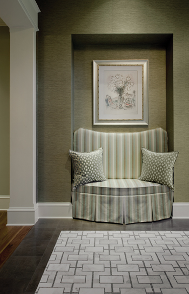 A shadowed alcove provides a nook for private conversation, livened with striped upholstery by Colefax and Fowler on a custom-made banquet.