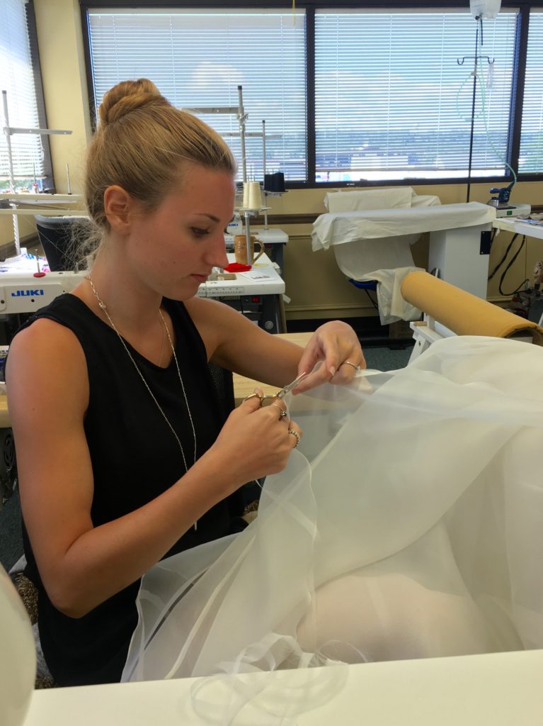 Meredith sews one of the dress' many layers. 