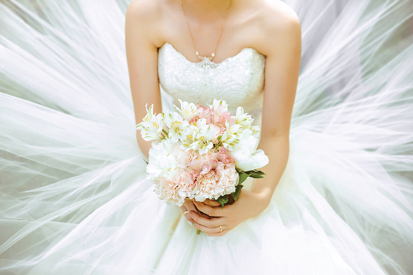 Bouquet of the bride in a magnificent white dress.